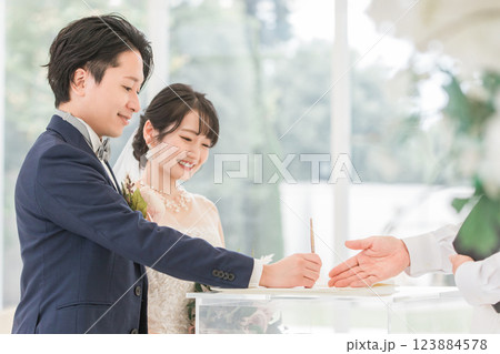 結婚式で結婚証明書・結婚誓約書にサイン・署名をする新郎新婦 123884578
