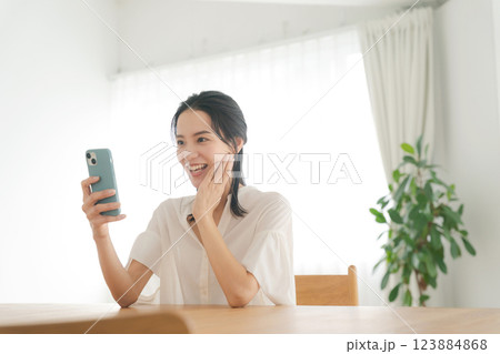 スマホを操作する笑顔の女性 スマホを操作する笑顔の女性 123884868