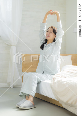 ベッドでストレッチするシニア女性 ベッドでストレッチするシニア女性 123885112