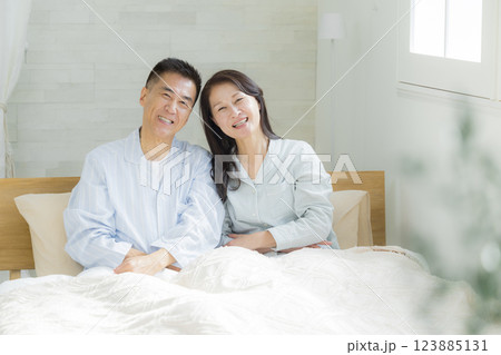 ベッドでストレッチするシニア夫婦　 123885131