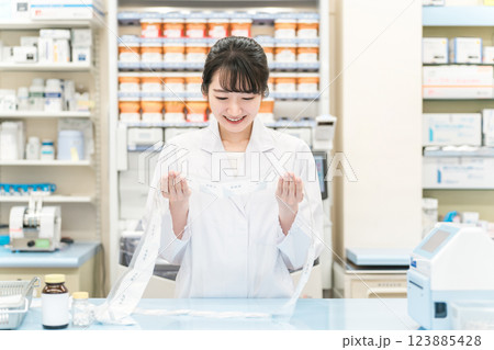 薬局・ドラッグストアで自動分包機を使って粉薬・調剤・処方箋を作る薬剤師 薬局・ドラッグストアで自動分包機を使って粉薬・調剤・処方箋を作る薬剤師 123885428