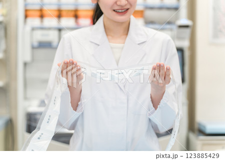 薬局・ドラッグストアで自動分包機を使って粉薬・調剤・処方箋を作る薬剤師 薬局・ドラッグストアで自動分包機を使って粉薬・調剤・処方箋を作る薬剤師 123885429