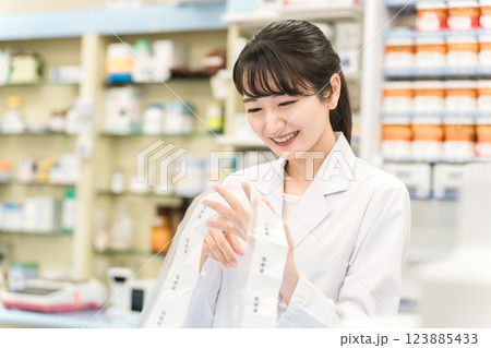 薬局・ドラッグストアで自動分包機を使って粉薬・調剤・処方箋を作る薬剤師 薬局・ドラッグストアで自動分包機を使って粉薬・調剤・処方箋を作る薬剤師 123885433