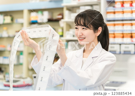 薬局・ドラッグストアで自動分包機を使って粉薬・調剤・処方箋を作る薬剤師 薬局・ドラッグストアで自動分包機を使って粉薬・調剤・処方箋を作る薬剤師 123885434