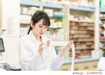 薬局・ドラッグストアで自動分包機を使って粉薬・調剤・処方箋を作る薬剤師 薬局・ドラッグストアで自動分包機を使って粉薬・調剤・処方箋を作る薬剤師 123885435