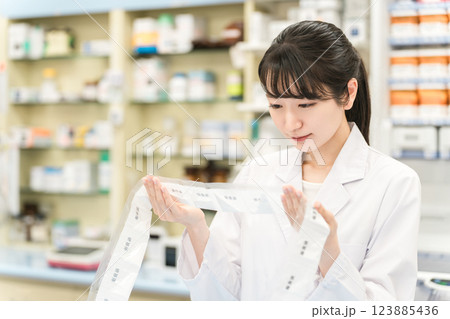 薬局・ドラッグストアで自動分包機を使って粉薬・調剤・処方箋を作る薬剤師 123885436