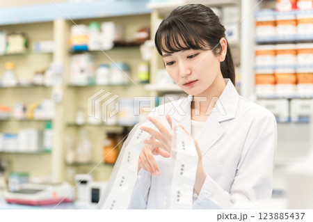 薬局・ドラッグストアで自動分包機を使って粉薬・調剤・処方箋を作る薬剤師 123885437