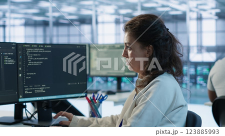 Portrait of smiling technician programming in AI data center used for machine learning training. Cheerful IT expert running code to upgrade artificial intelligence tech, camera A 123885993