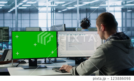 Software developer using green screen PC to do programming in server room providing computing resources for workloads. IT expert supervising data center supercomputers using mockup computer, camera A Software developer using green screen PC to do programming in server room providing computing resources for workloads. IT expert supervising data center supercomputers using mockup computer, camera A 123886098