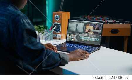 Video editor analyzing film montage on laptop screen before editing color grading and lighting in creative office. Post production studio employee working with raw footage on notebook, camera A 123886137