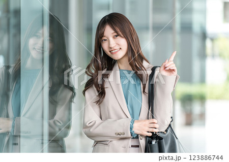 都会のオフィス街を歩く若いアジア人ビジネスウーマン 都会のオフィス街を歩く若いアジア人ビジネスウーマン 123886744