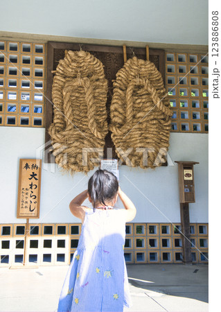 大きなわらじを撮影する少女 123886808