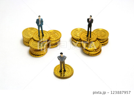収入格差とビジネスの成功 - 金貨の上のビジネスマンのミニチュア 収入格差とビジネスの成功 - 金貨の上のビジネスマンのミニチュア 123887957