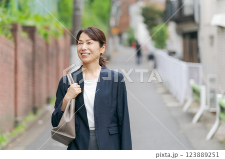 スーツを着て歩くミドル女性 123889251