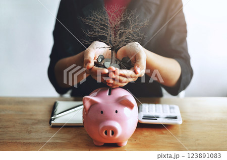 woman is holding a piggy bank full of coins 123891083