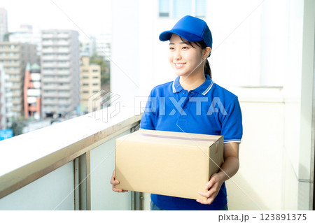 荷物を届ける宅配便の女性ドライバー 荷物を届ける宅配便の女性ドライバー 123891375