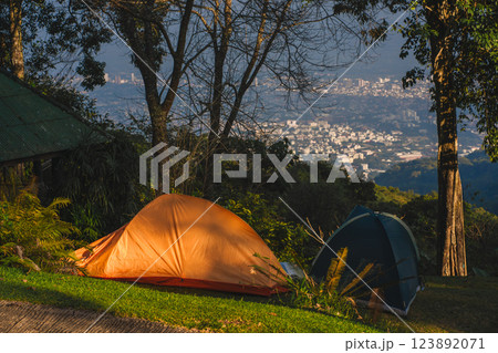 landscape and travel concept with camping tent on mountain and city background landscape and travel concept with camping tent on mountain and city background 123892071