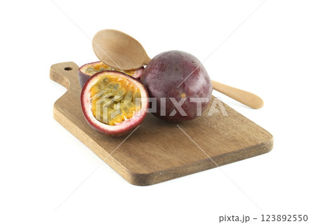 Fresh passion fruits and wooden spoon resting on cutting board 123892550
