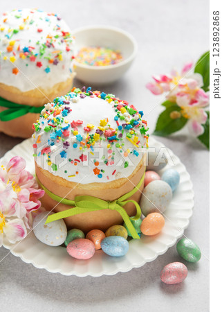 Easter cakes decorated with colorful sprinkles and chocolate eggs on festive table 123892868