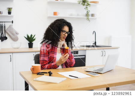 Young woman analyzing medication during online consultation with doctor at home for health concerns 123892961