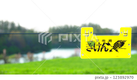 電気牧柵があるため危険の警告看板の風景 123892970