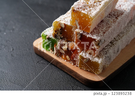 Turkish delight stacked on a wooden board, showcasing vibrant colors and textures in a close-up display Turkish delight stacked on a wooden board, showcasing vibrant colors and textures in a close-up display 123893238