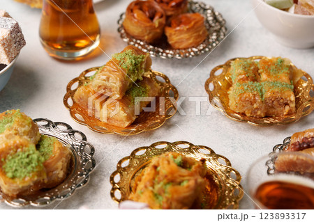 Delightful assortment of traditional pastries served with tea during a festive gathering in a cozy setting 123893317