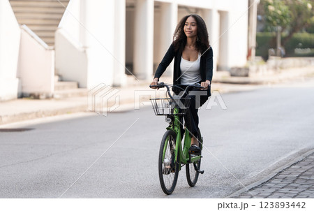 Sustainable Transportation and Urban Lifestyle. A young woman enjoying a bike ride in a vibrant urban environment. 123893442