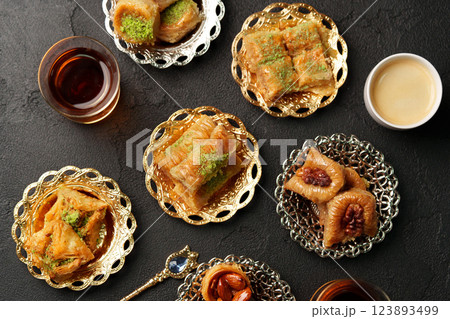 Baklava and tea served on ornate plates at a traditional dessert gathering in the afternoon 123893499