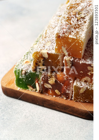 Turkish delight confectionery assortment with nuts and coconut on wooden serving board 123893501