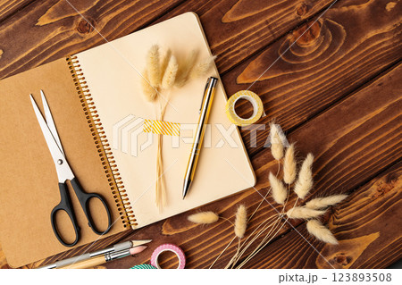 Creative workspace with stationery and natural elements on a wooden table 123893508