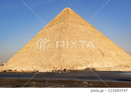 Majestic Great Pyramid standing tall under the clear blue sky in Giza, Egypt during late afternoon sunlight 123893547