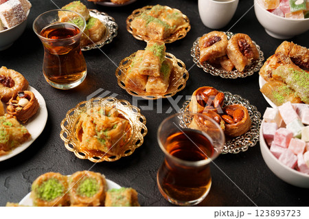 Traditional Middle Eastern sweets and pastries served on plates with tea in a cozy setting 123893723