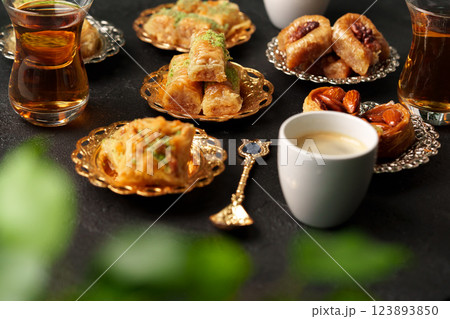 Delightful assortment of desserts and tea served on ornate dishes in a cozy setting Delightful assortment of desserts and tea served on ornate dishes in a cozy setting 123893850