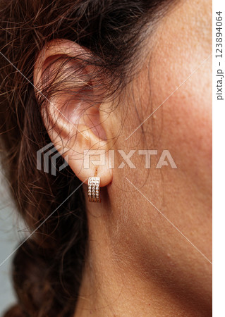 view of a woman wearing elegant diamond earrings 123894064