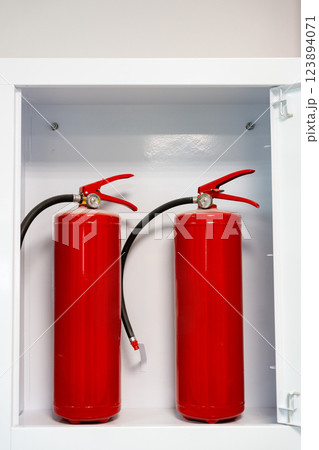 Fire safety equipment displayed in a storage cabinet for emergency preparedness 123894071