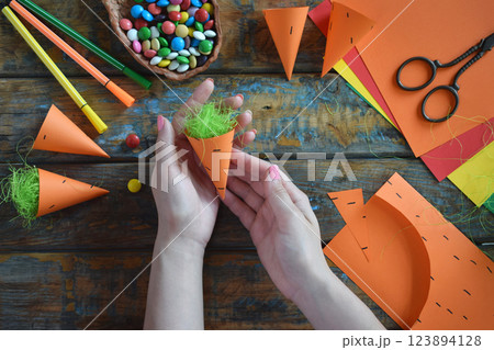 Carrots gift Bag for candies. DIY paper craft with your own hands together with children. Easter treat box. Art project for kids. Step by step guide. Carrots gift Bag for candies. DIY paper craft with your own hands together with children. Easter treat box. Art project for kids. Step by step guide. 123894128