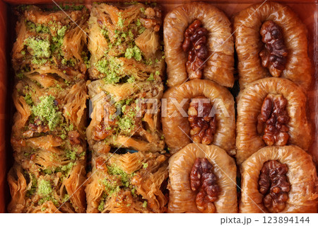 Delicious assortment of traditional pastries served in a wooden box with nuts and syrup 123894144