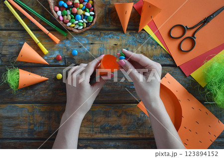 Carrots gift Bag for candies. DIY paper craft with your own hands together with children. Easter treat box. Art project for kids. Step by step guide. 123894152