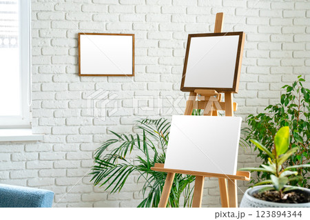 Art studio setup with empty canvas and fresh greenery surrounded by minimalist decor Art studio setup with empty canvas and fresh greenery surrounded by minimalist decor 123894344