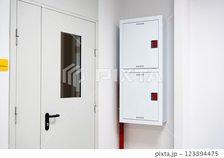 Utility area features safety equipment and a security door in a modern building setting 123894475