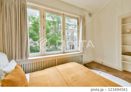 A warmly decorated interior showcasing large windows, soft textiles, and natural light, creating a serene and inviting atmosphere in a modern setting. 123894561