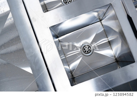 Stainless steel sink design showcases modern aesthetics and functionality in a contemporary kitchen setting 123894582