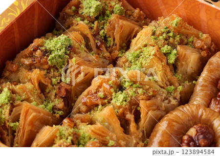 Sweet and flaky traditional pastry dessert served with pistachio topping in a decorative box Sweet and flaky traditional pastry dessert served with pistachio topping in a decorative box 123894584