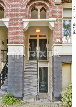 The image captures the ornate entrance of a historic building, featuring detailed brickwork and stylish doors, reflecting cultural architectural heritage. 123894720