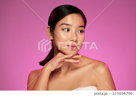 Elegant model posing gracefully against a vibrant pink backdrop showcasing beauty and confidence Elegant model posing gracefully against a vibrant pink backdrop showcasing beauty and confidence 123894796