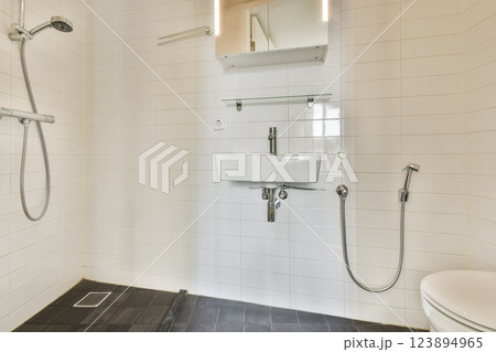 A sleek and contemporary bathroom featuring a walk-in shower with minimalistic fixtures and clean lines, perfect for modern living spaces. 123894965