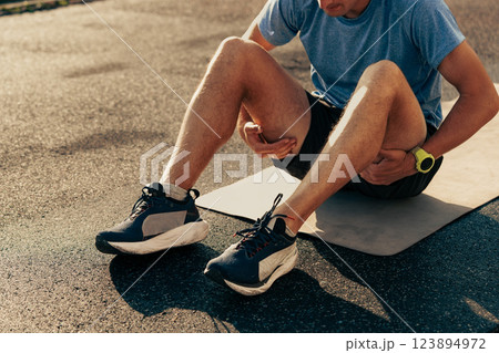 Runner experiencing muscle strain during exercise on a matte surface in the late afternoon light Runner experiencing muscle strain during exercise on a matte surface in the late afternoon light 123894972