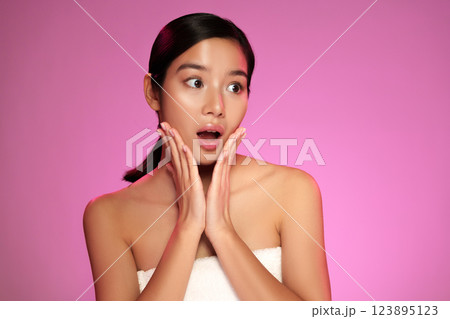 Woman expresses surprise against a vibrant pink background during a photo shoot in a studio setting Woman expresses surprise against a vibrant pink background during a photo shoot in a studio setting 123895123