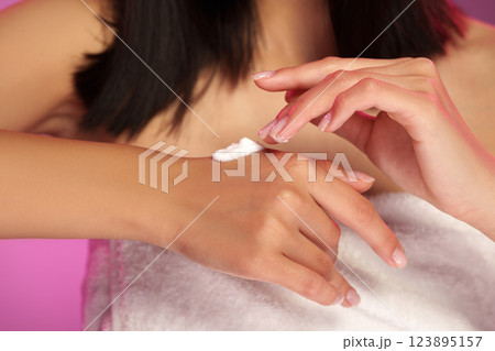 Applying moisturizer to skin in a relaxing indoor setting during evening hours 123895157